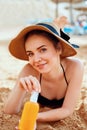 Sexy Young Woman in Bikini  Holding  Bottles of Sunscreen in Her Hands. Skincare. A Female  Applying Sun Cream Creme. Royalty Free Stock Photo