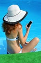 young woman in a hat with a phone near the pool Royalty Free Stock Photo