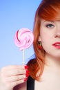 young woman holding candy. Redhair girl eating sweet lollipop Royalty Free Stock Photo