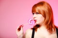 young woman holding candy. Redhair girl eating sweet lollipop Royalty Free Stock Photo