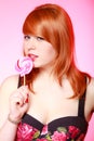 young woman holding candy. Redhair girl eating sweet lollipop Royalty Free Stock Photo