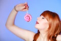 young woman holding candy. Redhair girl eating sweet lollipop Royalty Free Stock Photo