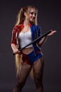 Sexy young woman in the image of Harley Quinn with a bat in her hands