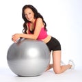 young woman kneeling with fitness ball