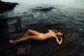 young woman lies on a rock ocean shore. Beautiful girl on stony background Royalty Free Stock Photo