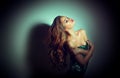 young woman portrait. Seductive brunette girl posing in darkness. Beauty glamour lady with long curly hair Royalty Free Stock Photo