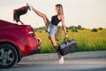 Sportive girl close car trunk with leg
