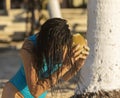 Sexy young woman sitting and listening to the coconut in her hands on the golden sand of a Caribbean beach in the mayan riviera Royalty Free Stock Photo