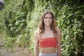Sexy young woman in tank top poses near ivy covered wall Royalty Free Stock Photo