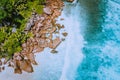 Seychelles La Digue Island. Aerial top view of ocean waves hitting huge bizarre granite rocks on the tropical beach anse Royalty Free Stock Photo