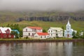 Wooden buildings and church in the port city of Seydisfjordur located by the fjord, Iceland