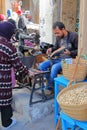 A cobbler at work inside the medina with a sewing machine