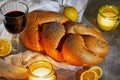 Shabbat challah with a white napkin, with candles, a glass of wine and rustic lemons. Shabbat Shalom