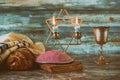 Shabbat eve table candles and cup of wine with covered challah bread