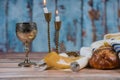 Shabbat eve table candles and cup of wine with covered challah bread