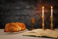shabbat image. challah bread, shabbat wine and candles on the table.