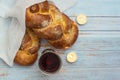 Shabbat Shalom - challah bread, shabbat wine and candles on blue wooden background. Top view. Copy space