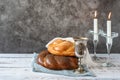 Shabbat Shalom - challah bread, shabbat wine and candles on grey background. With copy space