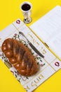 Shabbat shalom, challah on napkin with Kiddush and book on yellow background. Copy space, author`s processing.