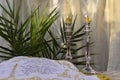 Shabbat table with olive oil candles burning on silver candlesticks and challah cover