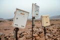 Shabby abandoned mail boxes stand before desertic landscape. Fuerteventura, Spain