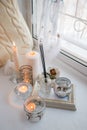 Shabby chic home design. Beautiful decoration table with a candles, dreamcacher, aroma stick on the windowsill, mindfullness relax