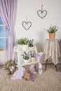 Shabby chic interior decor for farmhouse. Lavende,plant and vintage table,shelf over pastel wall. Provence home