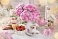 Shabby chic style interior with strawberry dessert and pink peonies on the table
