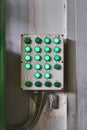 Shabby control panel for some industrial processes with luminous buttons on the wall in the workshop