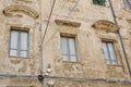 Shabby decadent wall with grey aged windows downtown in Alghero, Sardinia island, Italy