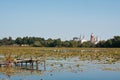 shabby and destroyed wooden fishing footbridge on river Riv with St. Anna Roman Catholic Church, Bar, Ukraine