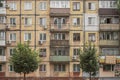 The shabby dirty facade of an old Soviet five-story panel house, called Khrushchevka, with windows and balconies.