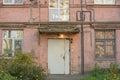 Shabby entrance group to an old residential building of the 1930s in the style of constructivism with chaotically arranged wires