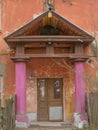 A shabby entrance with pink columns