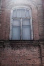 a shabby old window with shutters closed inside on a red brick wall Royalty Free Stock Photo