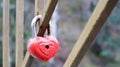 Shabby red lock in the shape of a heart. Valentine`s day love concept. A padlock hanging on a metal railing is a sign of eternal Royalty Free Stock Photo