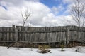 Shabby rustic wooden fence from boards in village at winter and Royalty Free Stock Photo