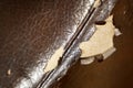 Shabby and worn brown faux leather texture background with cracks and damages, repairman background. Peeling faux leather couch Royalty Free Stock Photo