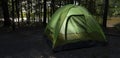 Shaded campsite with lighted tent Royalty Free Stock Photo