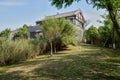 Shaded grassy slope before traditional building in sunny spring morning