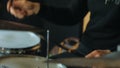 Shadeless man playing on drums and drum plates, side-view of the drum rehearsal