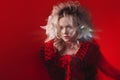 Shades of red. Portrait of Bizar attractive woman, with fashion make-up, in fantasy outfit, posing on a red background.