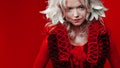 Shades of red. Portrait of a Bizarre attractive blond woman, with fashion makeup, in red fantasy outfit, zigzag collar.