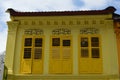 Shades of yellow on colonial windows and shutters in Little India , Singapore