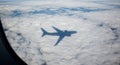 Shadow of an airplane on a blanket of white clouds, viewed from an aircraft window. Royalty Free Stock Photo