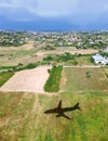 Shadow of an airplane flying over green fields Royalty Free Stock Photo