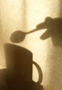 Shadow on beige wall with neutral pattern, cup and hand with spoon, wabi sabi aethetics