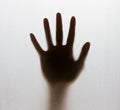 Shadow of a blurry hand behind the frosted glass Royalty Free Stock Photo