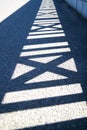 The shadow of the bridge railing on the pavement. Royalty Free Stock Photo