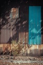 The shadow of the bright sunlight shining through trees and leaves front of Old and rusty zinc sheet wall house fence beautifully Royalty Free Stock Photo